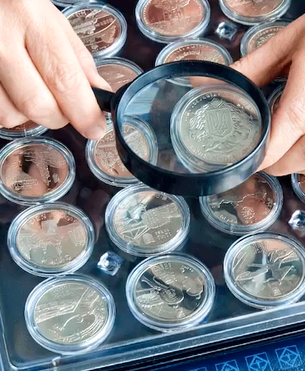 Person inspecting collectible coins magnifier